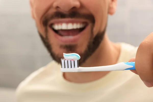 Homem Segurando Escova Com Pasta Dentes Contra Fundo Desfocado Close — Fotografia de Stock