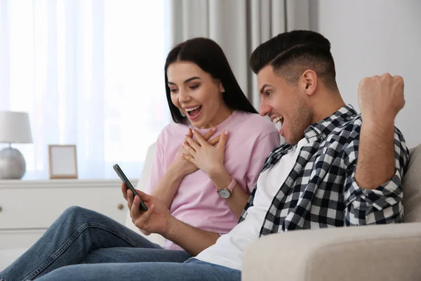 Emotionales Paar Bei Online Auktion Mit Smartphone Hause — Stockfoto