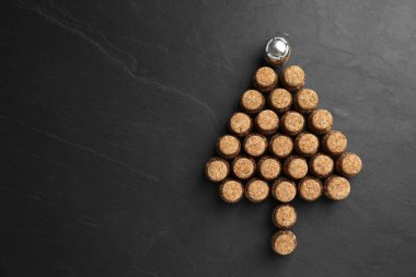 Siyah arka planda köpüklü şarap mantarlarından yapılmış Noel ağacı, düz. Metin için boşluk