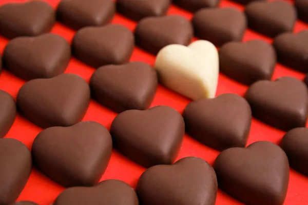Lekkere Hartvormige Chocolade Snoepjes Rode Achtergrond Close Gelukkige Valentijnsdag — Stockfoto