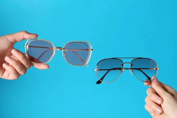 Mujeres Sosteniendo Gafas Sol Con Estilo Sobre Fondo Azul Claro —  Fotos de Stock