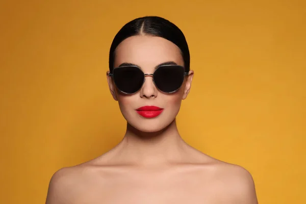 Atrakcyjna Kobieta Modnych Okularach Przeciwsłonecznych Pomarańczowym Tle — Zdjęcie stockowe