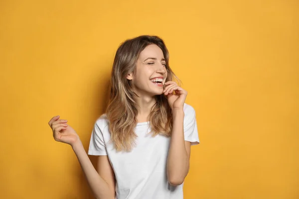 Fröhliche Junge Frau Lacht Auf Gelbem Hintergrund — Stockfoto