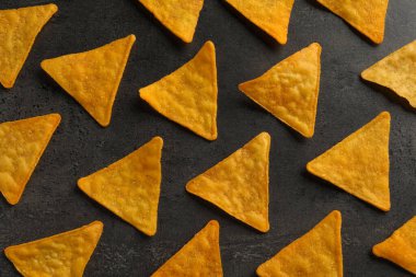 Gri masa üzerinde lezzetli tortilla cipslerinin (nachos) düz kompozisyonu