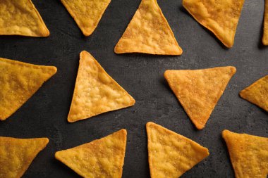 Gri masa üzerinde lezzetli tortilla cipslerinin (nachos) düz kompozisyonu