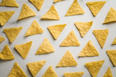 Beyaz masa üzerinde lezzetli tortilla cipslerinin (nachos) düz kompozisyonu