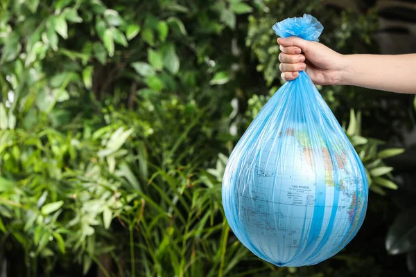 Woman Holding Globe Plastic Bag Green Leaves Closeup Space Text — Stok Foto