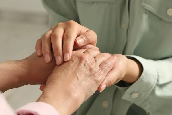 Young Elderly Women Holding Hands Indoors Closeup — ストック写真