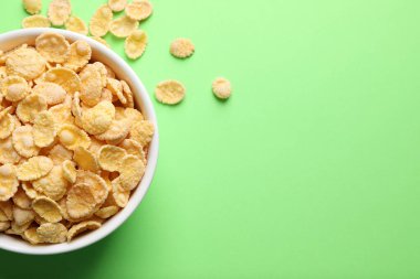 Açık yeşil arka planda gevrek mısır gevreği kasesi, düz. Metin için boşluk