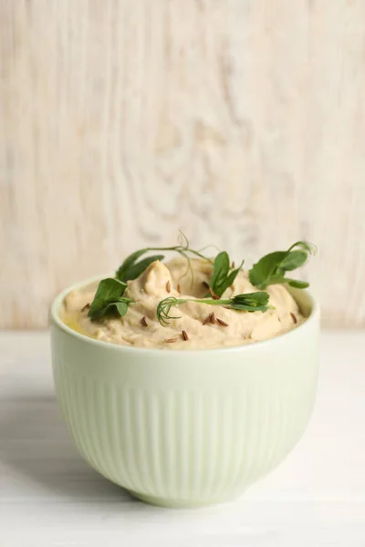 Schüssel Mit Leckerem Humus Mit Erbsenblättern Auf Weißem Holztisch Platz — Stockfoto