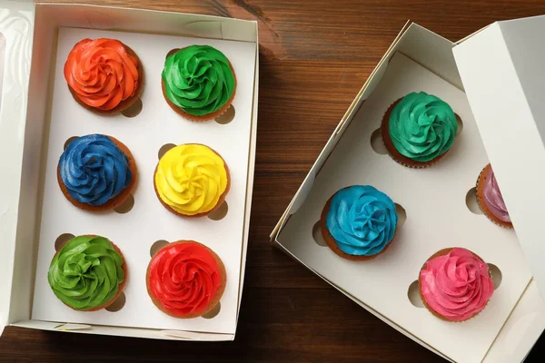 Caixas Com Deliciosos Cupcakes Coloridos Mesa Madeira Flat Lay — Fotografia de Stock