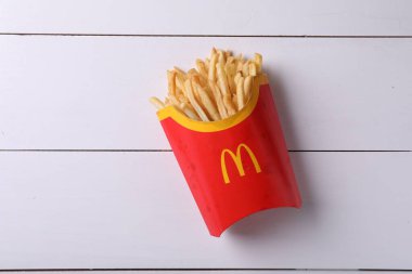 MYKOLAIV, UKRAINE - 12 Ağustos 2021: Beyaz ahşap masa üzerinde McDonald 's patates kızartmasının büyük bir kısmı,