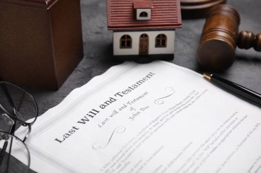 Son arzum ve vasiyetim ev modeli, gözlükler ve tokmak gri masada, yakın plan.