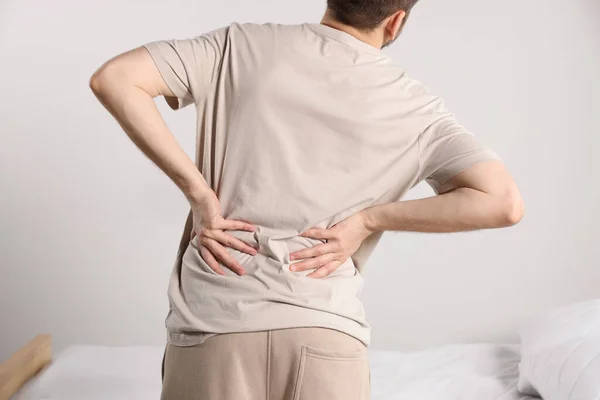 Man Suffering Back Pain While Standing Bed Room Closeup Symptom — Stock Photo, Image