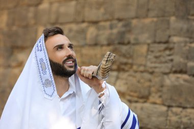 Yahudi bir adam Rosh Hashanah 'ı açık havada uçuruyor. Evrenin hükümdarı, bizi emirleriyle kutsayan ve kendimizi İbranice Tzitziton 'a sarmamızı emreden Tanrı' mız, sen kutsanmış olansın.