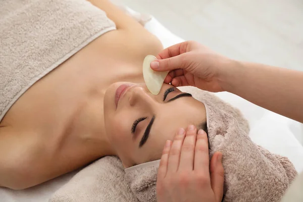 Jonge Vrouw Ontvangt Gezichtsmassage Met Gua Sha Gereedschap Schoonheidssalon — Stockfoto