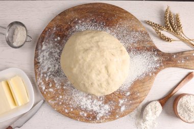 Taze hamur serpiştirilmiş un ve diğer malzemeler beyaz ahşap masa üzerinde, düz yatıyordu.