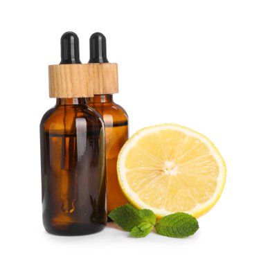 Bottles of citrus essential oil and fresh lemon isolated on white