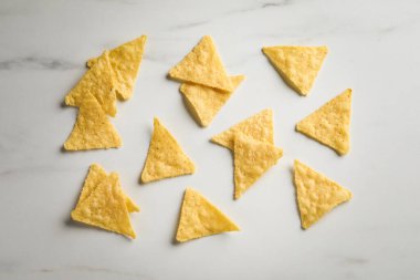 Beyaz masa üzerinde lezzetli tortilla cipslerinin (nachos) düz kompozisyonu