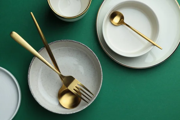 Κομψά Άδεια Πιάτα Και Χρυσά Μαχαιροπήρουνα Πράσινο Φόντο Επίπεδο Lay — Φωτογραφία Αρχείου