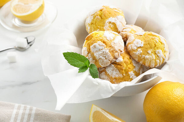 Tasty homemade lemon cookies with fresh fruit and mint on white marble table