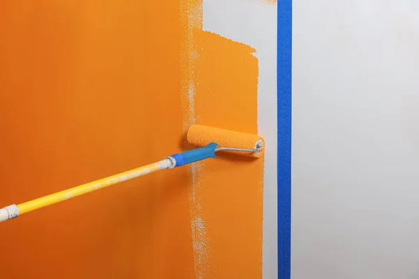 Person Bemalt Wand Mit Walze Und Orangenfarbstoff — Stockfoto