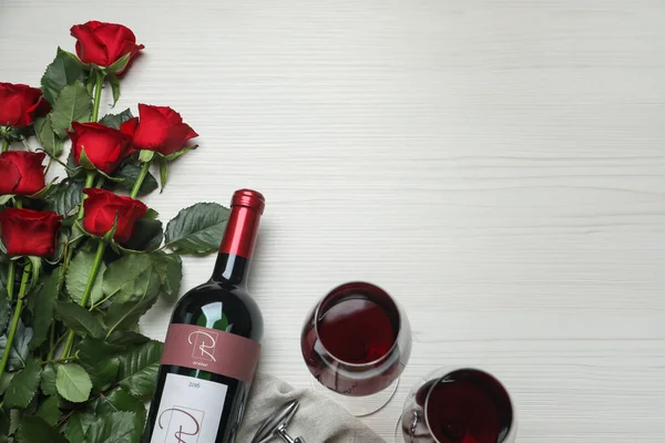 红葡萄酒 白木桌上有美丽的玫瑰 平平的躺着 案文的篇幅 — 图库照片