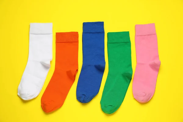 Verschiedene Bunte Socken Auf Gelbem Hintergrund Flache Lage — Stockfoto