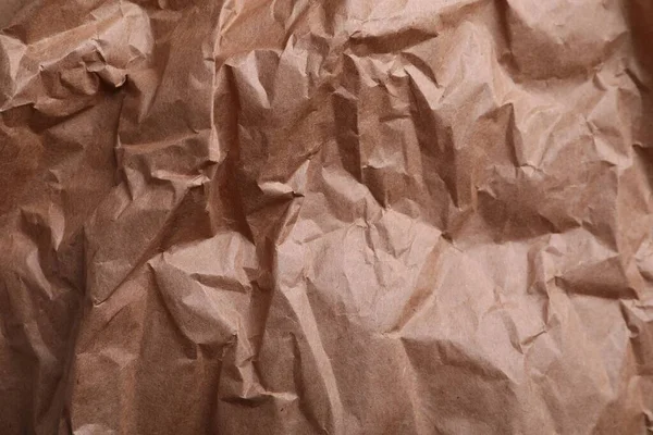 Texture of wrinkled kraft paper bag as background, closeup