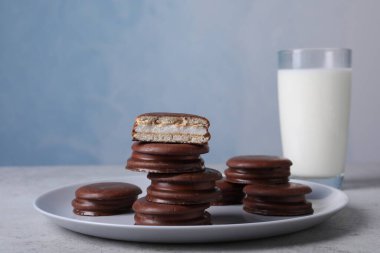 Gri masada lezzetli çikolatalı turtalar ve süt.