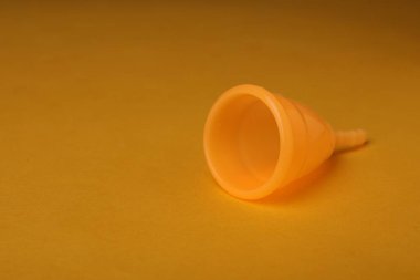 Sarı arka planda regl fincanı. Metin için boşluk