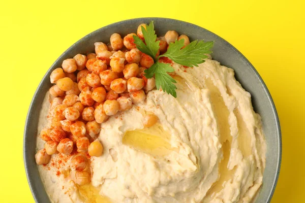 Schaal Van Smakelijke Hummus Met Kikkererwten Peterselie Gele Achtergrond Bovenaanzicht — Stockfoto