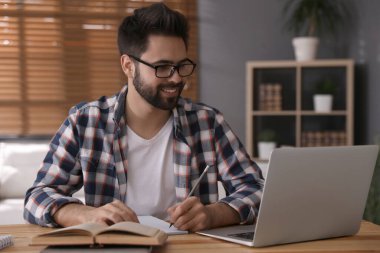 Genç adam masadaki Webinar 'ı izliyor.