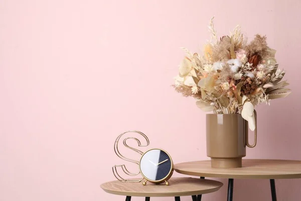 ピンクの壁の近くの木製のテーブルの上に乾燥した花や葉を持つスタイリッシュなセラミック花瓶 テキストのスペース — ストック写真