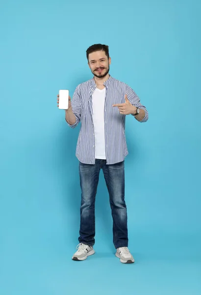 Smiling Man Pointing Smartphone Light Blue Background — Stock Photo, Image