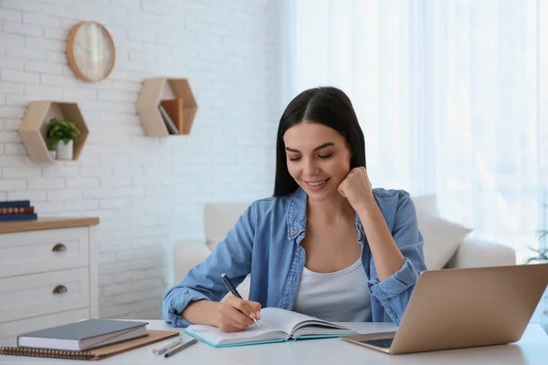 Jonge Vrouw Neemt Aantekeningen Tijdens Online Webinar Aan Tafel Binnen — Stockfoto