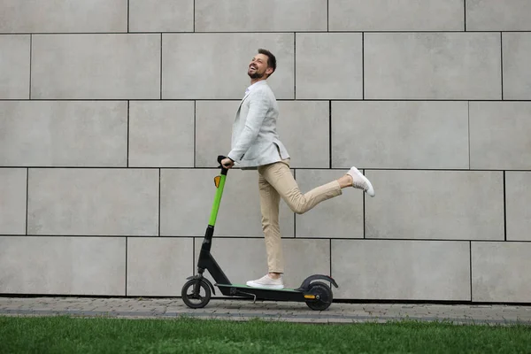 Hombre Negocios Montando Patinete Scooter Moderno Cerca Pared Piedra Gris —  Fotos de Stock