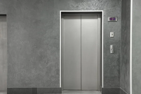 Closed stylish elevator door in clean hall
