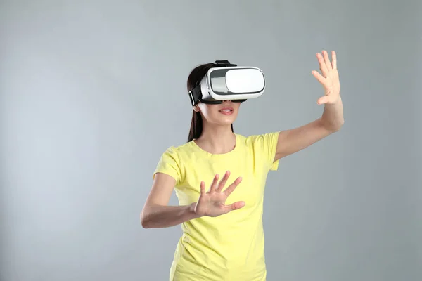 Mulher Usando Fone Ouvido Realidade Virtual Fundo Cinza — Fotografia de Stock