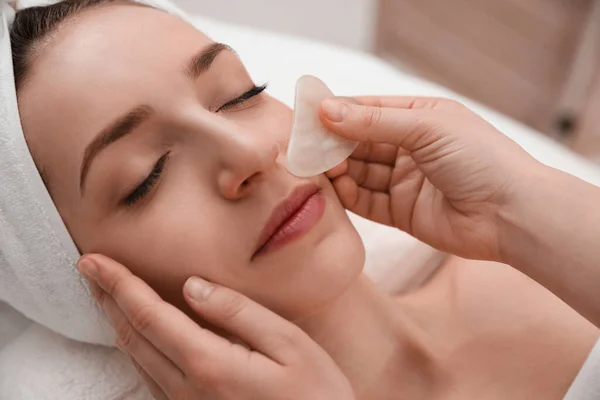 Mujer Joven Recibiendo Masaje Facial Con Herramienta Gua Sha Salón — Foto de Stock