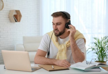 İçerideki masada internetten giysi izleyen genç adam.