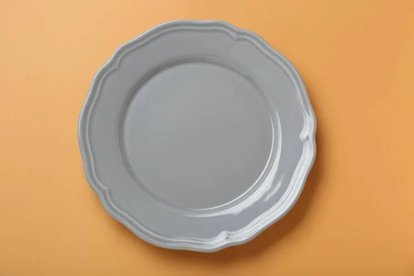 Пустая Керамическая Плита Бледно Оранжевом Фоне Вид Сверху — стоковое фото