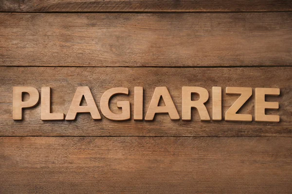 テーブルの上に木製の文字で作られた単語のPlagiarize フラットレイアウト — ストック写真