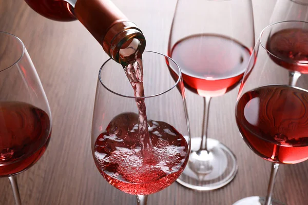 Pouring Rose Wine Bottle Glasses Wooden Table Closeup — Stock Photo, Image