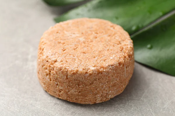 Natural solid shampoo bar on grey table, closeup