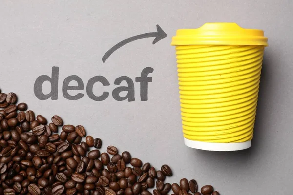 Koffiebonen Woord Decaf Pijl Wijzend Afhaalpapier Beker Lichtgrijze Achtergrond Plat — Stockfoto