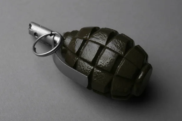 Hand grenade on grey background, closeup. Explosive weapon