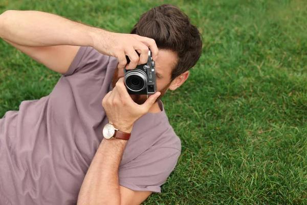 男人带着相机在绿草上拍照 文字空间 有趣的爱好 — 图库照片