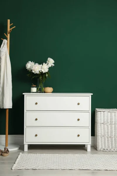 室内绿墙附近的现代白色抽屉 衣架和柳条篮 — 图库照片