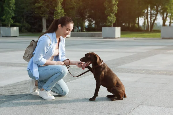 年轻女子带着她的德国短腿猎犬在城市街道上 — 图库照片